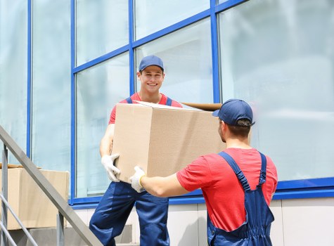 Professional movers carrying furniture through a Wandsworth residential street