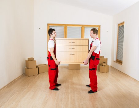 Removal team carrying furniture through a Wandsworth residential street